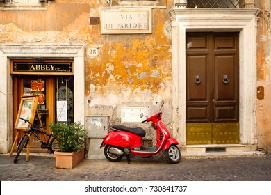 ROME.ITALY - JULY 21, 2017 : Typical street scene in Rome with a red scooter on an old narrow cobblestoned street
