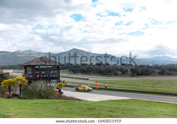 Ronda, Malaga / Spain - February 07 2020: Ascari circuit\
in Spain in a ordinary day. Pilot practising for races. Cloudy day.\
mountains in background. The logo of Ascari. Expensive race car.\
