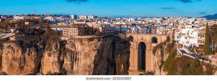 Ronda, Spain, features the Puente Nuevo bridge over El Tajo gorge, with whitewashed buildings and narrow streets illuminated by the setting sun. - Powered by Shutterstock