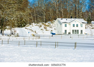 Ronneby, Sweden - March 28, 2018: Documentary of everyday life and environment. White house with empty paddock in winter landscape after a cold and snowy night. Spring is late this year.