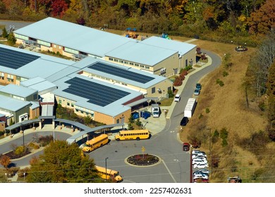 Roof of american school building covered with photovoltaic solar panels for production of electric energy. Renewable energy concept - Shutterstock ID 2257402631