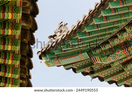 The roof of a building is decorated with a dragon. The dragon is on the top of the roof and is surrounded by other decorations