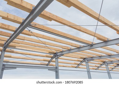 Roof construction from timber beams and steel frames. Agricultural building construction