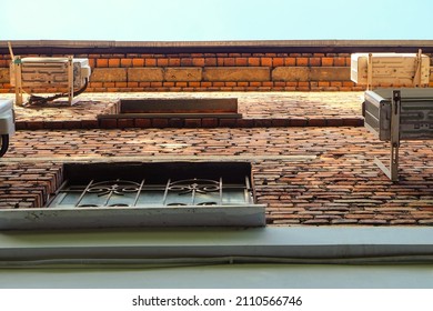 Roof cornice of an old multi-storey building made of ceramic bricks. View from bottom to top.