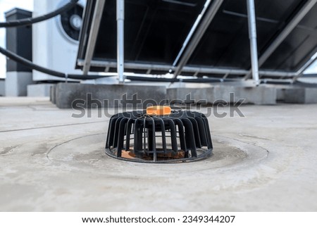 Roof drain with vents on the surface of a flat roof