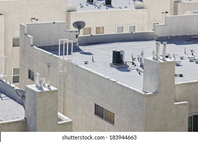 Roof is flat with air conditioners on top of a modern apartment.