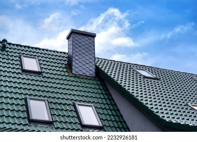 Roof with green roof tiles , the chimney is covered with gray slate shingles