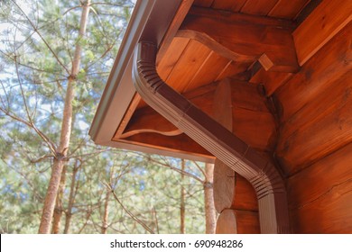 Roof gutter system on log house in forest
