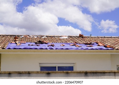 roof home covered with a tarp waiting for the roofing company to fix after thunderstorm - Shutterstock ID 2206470907