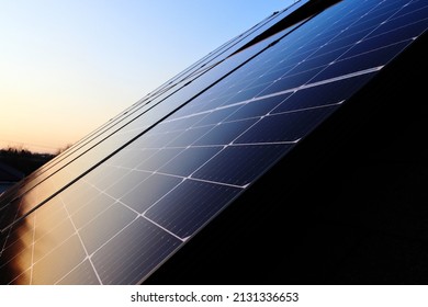 The roof of the house is covered with photovoltaic panels. Sunset. Green energy. Photovoltaic power plant on the roof of the house. - Shutterstock ID 2131336653