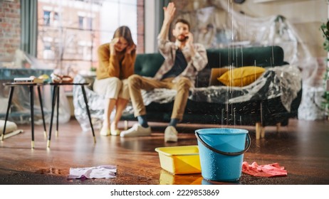 Roof is Leaking, Pipe Rupture at Home: Angry Couple Calling Insurance Company, Screaming into Phone in Frustration, Trying to Find Plumber, Master. Water Drips into Buckets in Living Room. Rack Focus - Shutterstock ID 2229853869