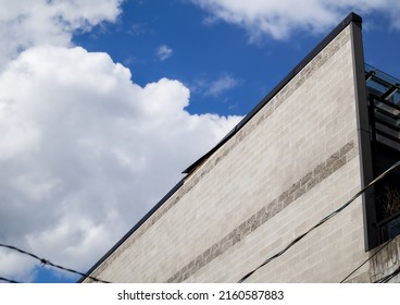 Roof Metal Flashing Bent Or Blown-off From Wind. Damage To The Aluminum Flashing At The Top Edge Of The Building With Flat Roof. Roofer Needed To Repair, Fix, Seal And Waterproof. Selective Focus. 