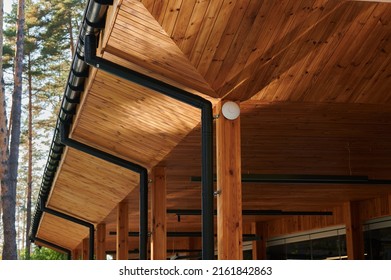 The Roof Of An Open Veranda Made Of Wood Trim With Plastic Pipes For Rain Gutters, An Element Of Architecture