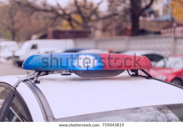 Roof of a  patrol car with flashing blue and\
red  lights, sirens and\
antennas.