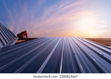 Roof repair, Construction worker installing new roof, roofing tools, power drill used on new roof with sheet metal. Roofing - construction worker standing on a roof covering it with metal. - Shutterstock ID 2280824667