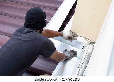Roof repair, Worker with steel sheet. Stop a roof leak