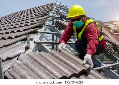 Roof Repair, Worker With White Gloves Replacing Gray Tiles Or Shingles On House With Blue Sky As Background And Copy Space, Roofing - Construction Worker Standing On A Roof Covering It With Tiles.