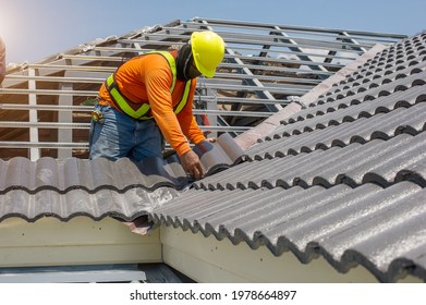 Roof Repair, Worker With White Gloves Replacing Gray Tiles Or Shingles On House With Blue Sky As Background And Copy Space, Roofing - Construction Worker Standing On A Roof Covering It With Tiles.