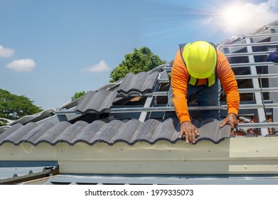 Roof Repair, Worker With White Gloves Replacing Gray Tiles Or Shingles On House With Blue Sky As Background And Copy Space, Roofing - Construction Worker Standing On A Roof Covering It With Tiles.