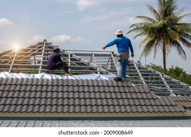 Roof Repair, Worker With White Gloves Replacing Gray Tiles Or Shingles On House With Blue Sky As Background And Copy Space, Roofing - Construction Worker Standing On A Roof Covering It With Tiles.