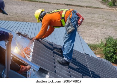 Roof Repair, Worker With White Gloves Replacing Gray Tiles Or Shingles On House With Blue Sky As Background And Copy Space, Roofing - Construction Worker Standing On A Roof Covering It With Tiles.