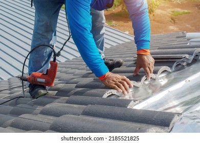 Roof Repair, Worker With White Gloves Replacing Gray Tiles Or Shingles On House With Blue Sky As Background And Copy Space, Roofing - Construction Worker Standing On A Roof Covering It With Tiles.
