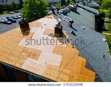 Roof repairs old roof replacement with new shingles of an apartment building