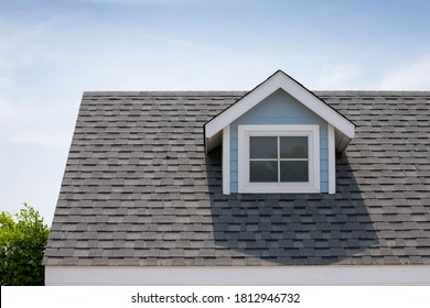 Roof shingles with garret house on top of the house among a lot of trees. dark asphalt tiles on the roof background - Shutterstock ID 1812946732