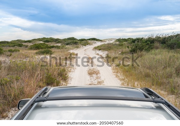 Roof top view of van life camper driving 4x4 overland\
vehicle on unmarked trail road exploring public land in search of a\
campsite 