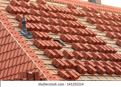 A roof under construction with stacks of roof tiles ready to fasten