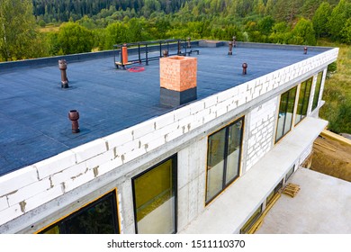 Roof waterproofing. Building construction. A protective layer was applied on the roof of the house. Installation of a waterproofing layer. Construction works. Bitumen insulating layer.