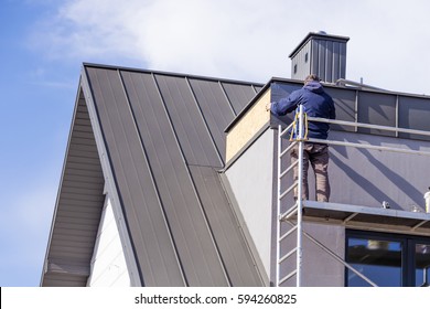 Roofer Assembles Sheet Metal On The Roof. Roofers On The Roof.