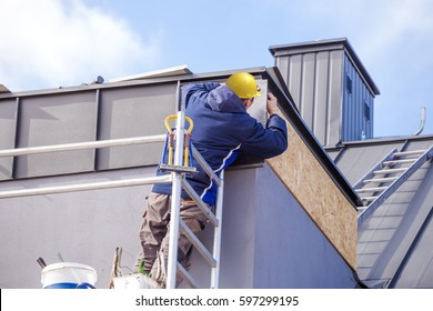 Roofer Assembles Sheet Metal On The Roof. Roofers On The Roof.