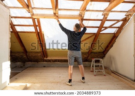 Roofer is changing the rafter for a bigger window in the attic.