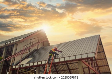 Roofer Construction worker install new roof,Roofing tools on during sunset,Electric drill used on new roofs with Metal Sheet.