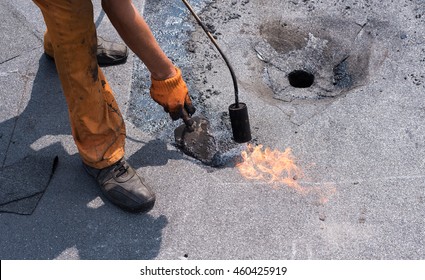 
 Roofer Doing Repair  Roof Drain. Flat Roof Installation. Heating And Melting Bitumen Roofing Felt. Flat Roof Repairing With Roofing Felt. Professional Master , Making Waterproofing.