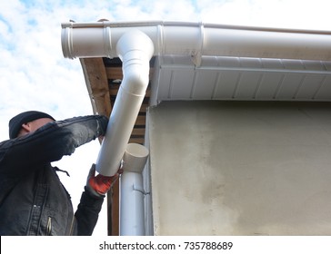 Roofer Install And Repair Gutter System. Rain Gutter Installation With Drain Downspout Pipe. Guttering.