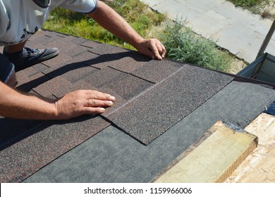 Roofer installing asphalt shingles on house construction roof corner. Roofing construction. Roofing contractor install roof tiles. - Shutterstock ID 1159966006