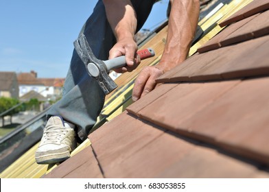 Roofer Nailing Slats On A Roof For Renovation