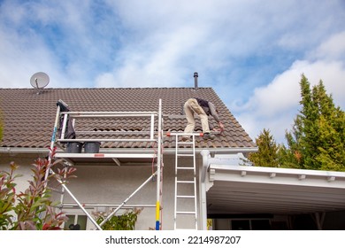 Roofer, Worker On The Rooftop. Roofing Work. Solar Cell Installation. Preparation Of Solar Panel Installation. Attaching Rails. Scaffolding On Construction Site