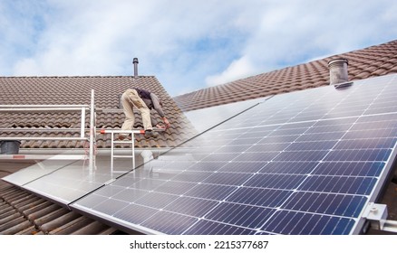 Roofer, Worker On The Rooftop. Roofing Work. Solar Cell Installation. Preparation Of Solar Panel Installation. Attaching Rails. Scaffolding On Construction Site