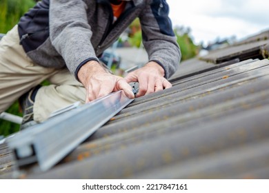 Roofer, Worker On The Rooftop. Roofing Work. Solar Cell Installation. Preparation Of Solar Panel Installation. Attaching Rails On Construction Site