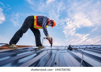 Roofer Working On Roof Structure Of Building In Construction Site, Roof Metal Sheet Construction Concept.