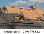 Roofers completely replace old asphalt shingle roof during summer in Canada