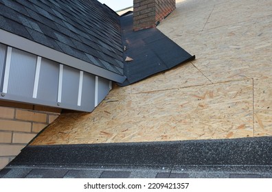 Roofing construction with asphalt shingles corner waterproofing. Close up on laying asphalt shingles in the house attic rooftop corner problem area. Repair asphalt shingles attic roof. - Shutterstock ID 2209421357