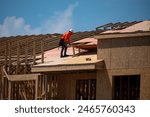 Roofing construction. Roofer roofing on roof structure. Roofing Wooden House Frame. Worker roofer builder working on roof at construction site. Construction builders Roofing.