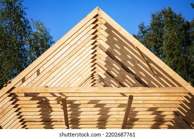 Roofing construction. Wooden roof frame during house construction. Focus on the front planks. - Shutterstock ID 2202687761