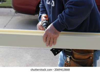 Roofing Contractor  Preparing Seamless Gutter To Be Installed On A Residential Building