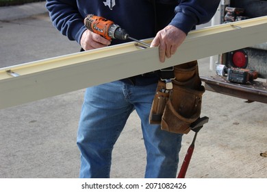 Roofing Contractor  Preparing Seamless Gutter To Be Installed On A Residential Building