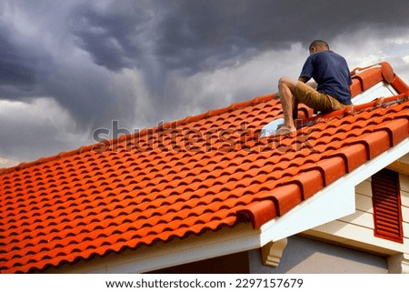 roofing contractor Seal the roof leaks with  sealant in the rainy season, on the backdrop of the sky in the rainy season Сток-фото © 